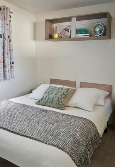 De slaapkamer met 1 tweepersoonsbed in de comfortabele stacaravan Turenne, te huur op camping le Médiéval in de Elzas