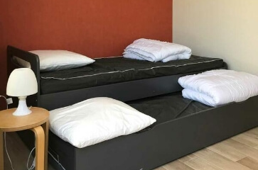 Chambre équipée d'un espace lumineux avec 2 lits simple, de l’hébergement Stop étape Access, du camping le Médiéval labélisé accueil vélo à Turckheim